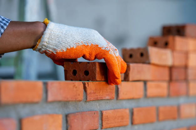 ouvrier-industriel-macon-installation-maconnerie-brique-mur-exterieur-